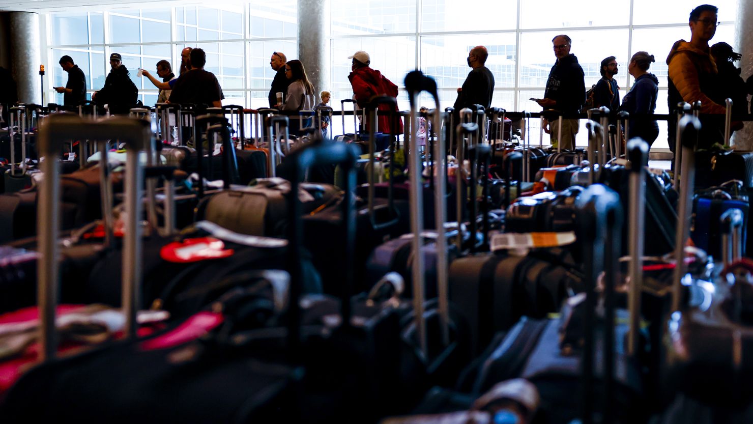 Travelers wait in line before they are allowed to search for their luggage in a baggage holding area for Southwest Airlines at Denver International Airport on December 28, 2022 in Denver, Colorado. 
