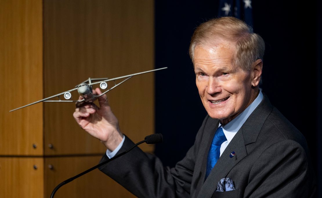 NASA Administrator Bill Nelson holds a model of an aircraft with a Transonic Truss-Braced Wing.