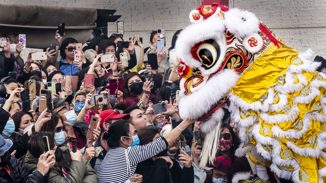 Visitors give offerings to a lion for good luck during a 2022 Lunar New Year celebration in Westminster, California.