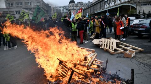 Palet kayu terbakar, ketika para demonstran berkumpul selama rapat umum yang dipanggil oleh serikat pekerja Prancis di luar Gare de Lyon, di Paris pada 19 Januari 2023.