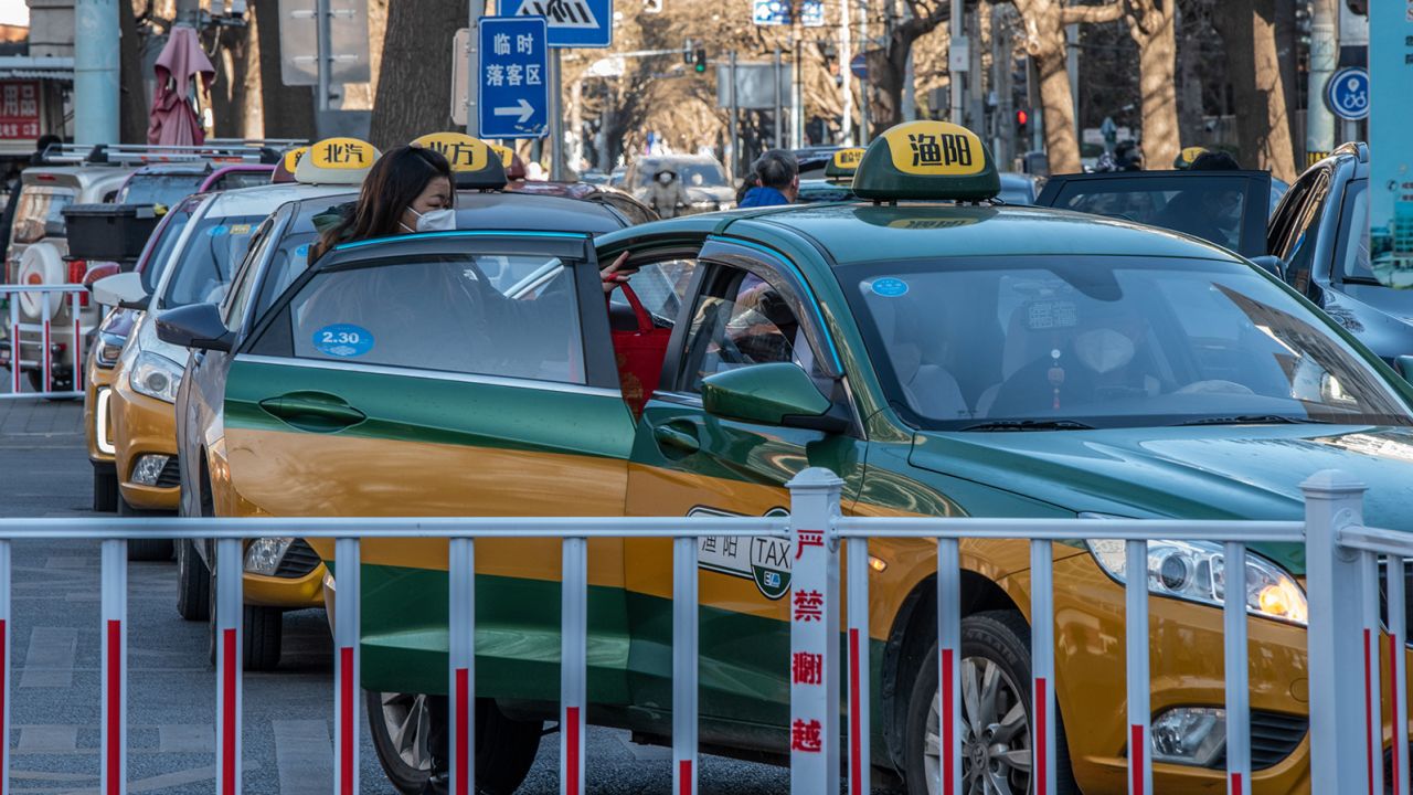 A woman gets in a taxi in Beijing, China, on Thursday, Dec. 29, 2022. 