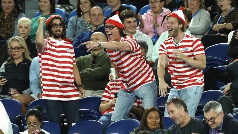 Fans di kerumunan berpakaian 'Di mana Waldo?'  kostum terlihat selama pertandingan antara Djokovic dan Couacaud.