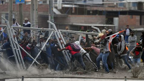 Demonstrators pull down a fence while trying to enter Arequipa's airport. 