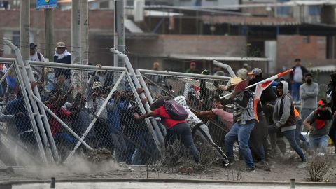 Protesters pull down fences as they try to enter Arequipa's airport. 