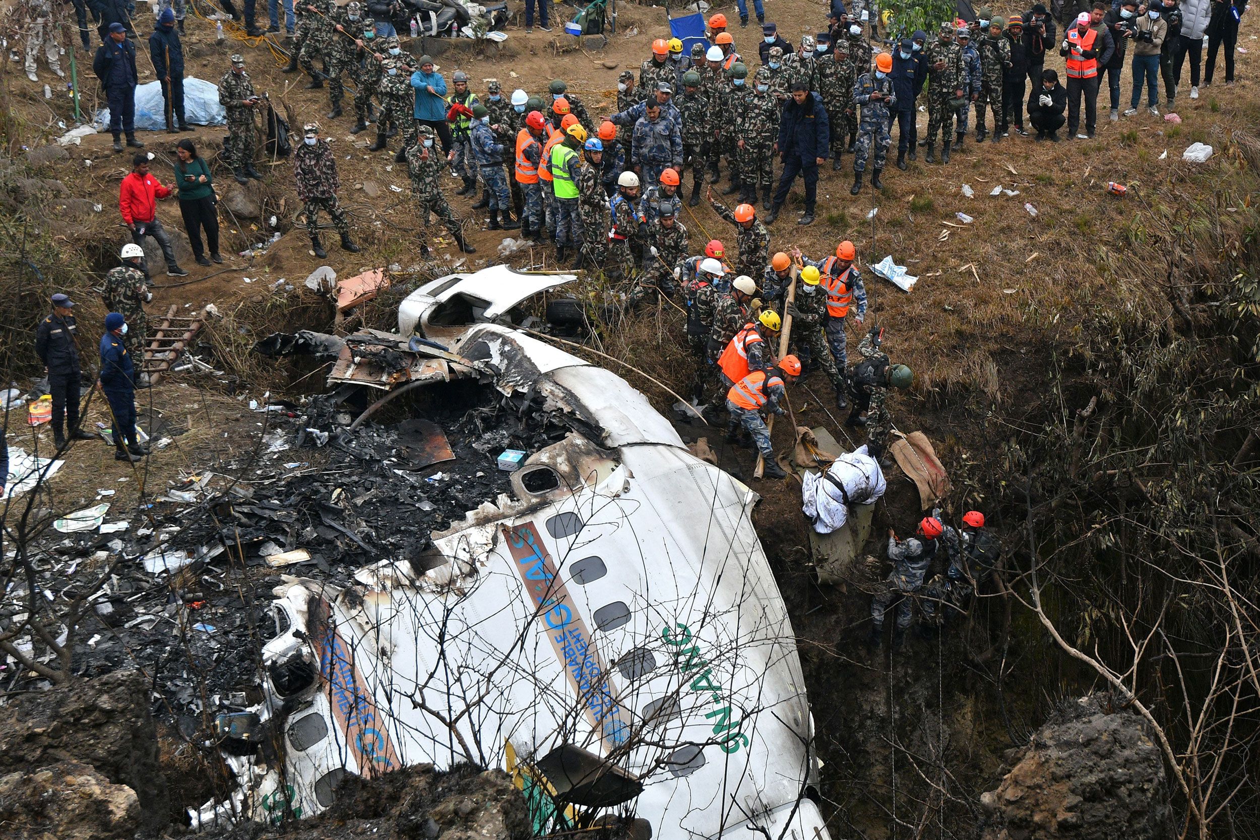 Rescuers at the site of a plane crash in Nepal.