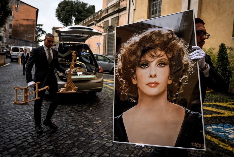 An employee carries a photo of late actress Gina Lollobrigida ahead of her lying in state at Rome's Capitoline Hill on Wednesday, January 18.  The Italian screen legend died at the age of 95, news agency ANSA reported, citing members of her family.