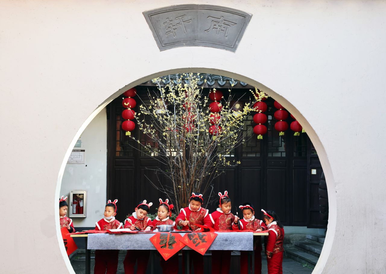 Children wearing bunny ears write the Chinese character "Fu," meaning "good luck," on Monday, January 16 in Huzhou, China. The Year of the Rabbit starts on January 22.