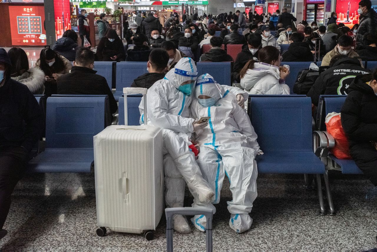 Travelers wear protective gear at a railway station in Jinan, China, on January 15. There are growing concerns that this month's Lunar New Year will see the coronavirus sweep across the country as hundreds of thousands of people travel home.