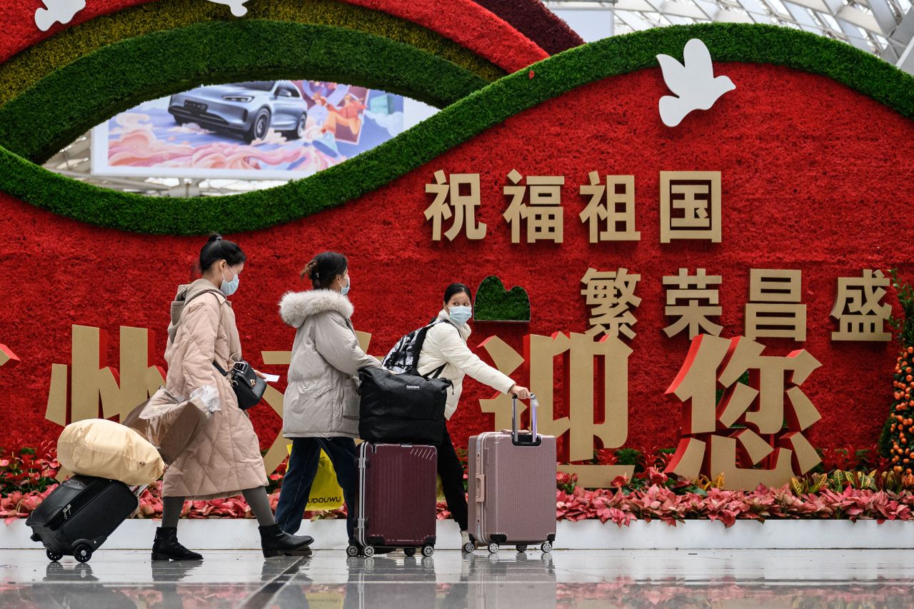 Passengers walk through a railway station in Guangzhou, China, on Thursday, January 12, as they prepare to travel to their hometowns for the Lunar New Year.
