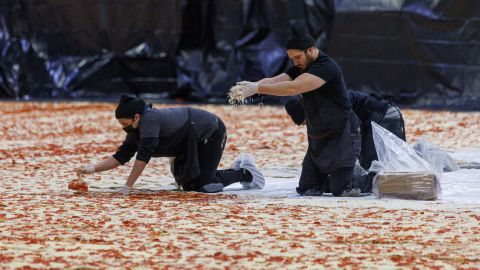 Cooks work inside the Los Angeles Convention Center on January 18, 2023, to create the world's largest pizza.