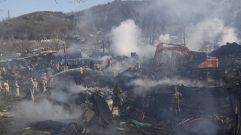 20 जनवरी को दक्षिण कोरिया के सियोल में गुरयोंग गांव में आग लगने के स्थान पर अग्निशामक और बचावकर्मी।