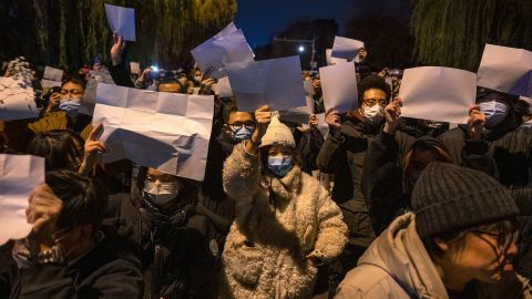 People hold up blank pieces of paper during a protest against China's zero-Covid measures on November 27, 2022 in Beijing, China.