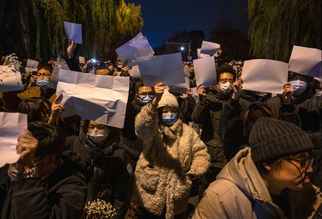 People hold up blank pieces of paper during a protest against China's zero-Covid measures on November 27, 2022 in Beijing, China. 