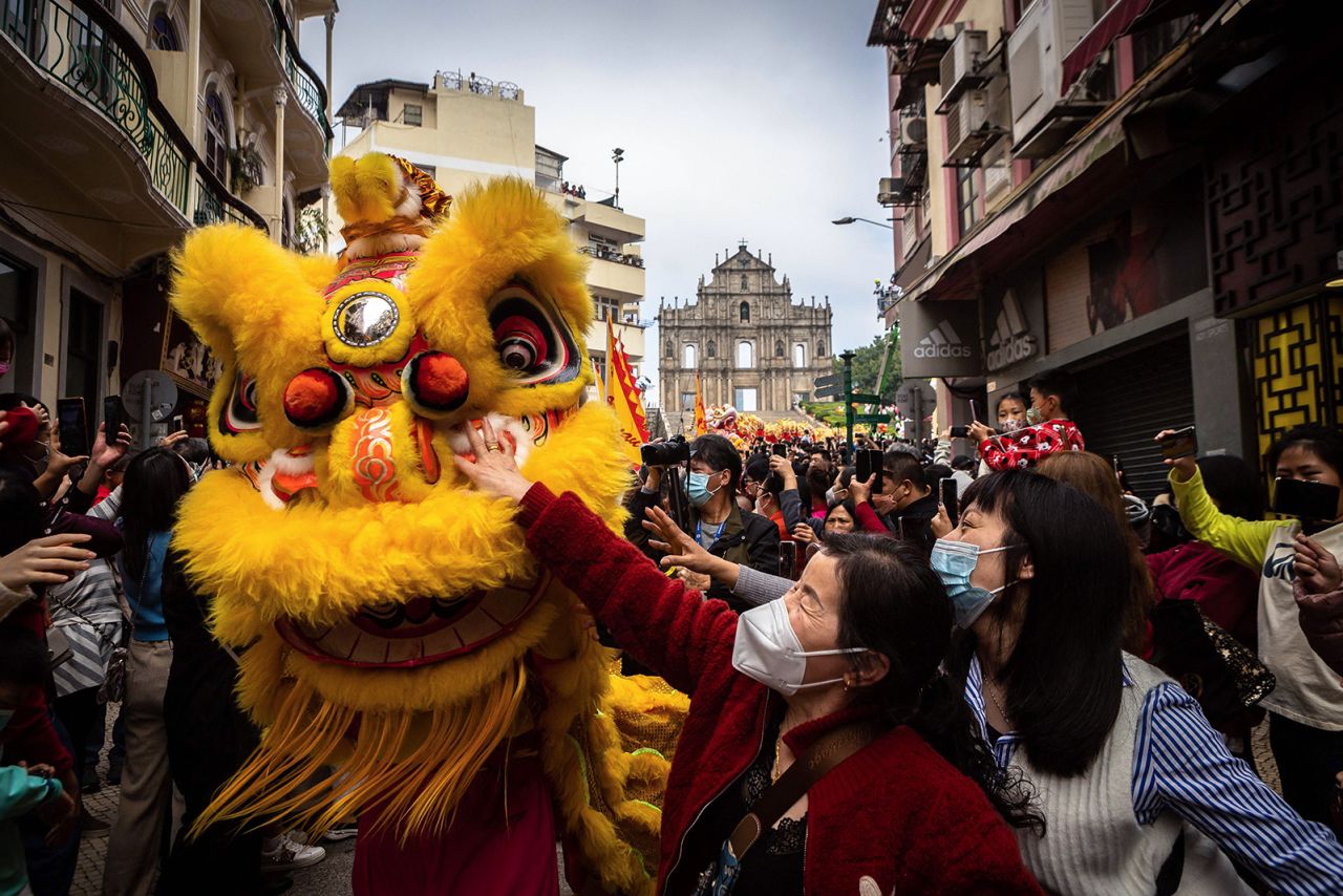 Women reach to touch a traditional Lion dance performer for good luck in front of the Ruins of St. Paul's during Lunar New Year celebrations in Macao on January 22.
