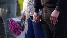 A couple holds flowers and hands at a community vigil near the scene of the shooting in Monterey Park, California.
