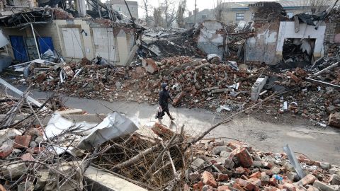 A woman walks by destroyed buildings 20 miles west from the front lines of fighting in Ukraine's Donetsk Region on January 20. Russia has stepped up its offensive in the region since the start of the year.