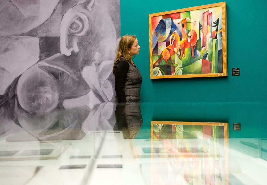 A woman looks at the forgery "Zwei rote Pferde in der Landschaft" ("Two Red Horses in Landscape"), which Wolfgang Beltracchi created in the style of artist Heinrich Campendonk, at the Moritzburg art museum in Halle, Germany, in 2014.