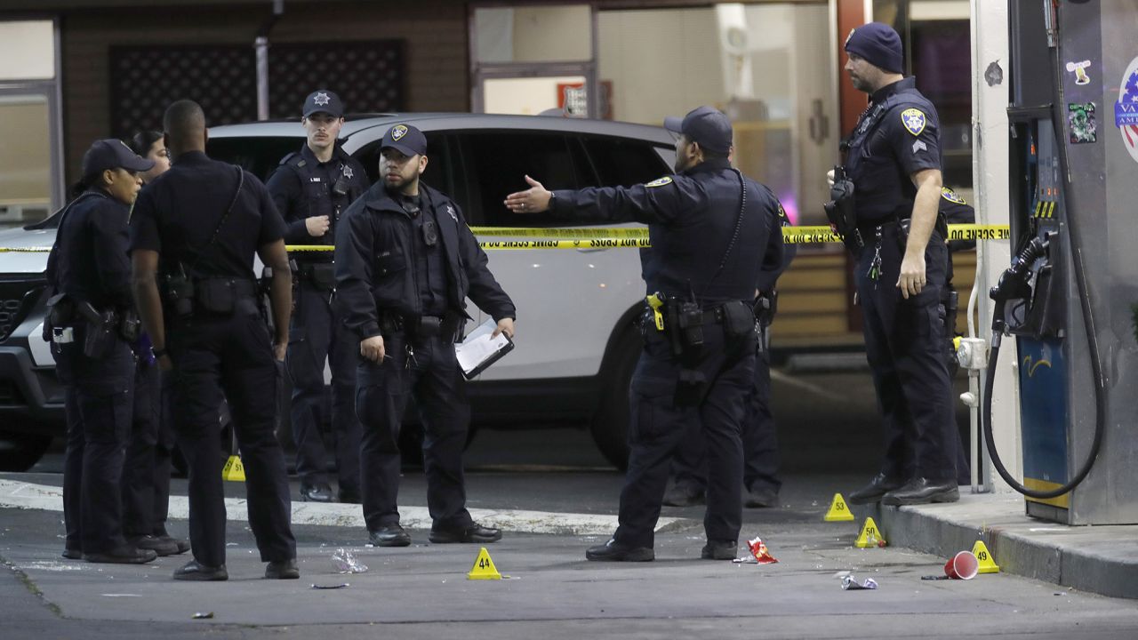 Police officers investigate a mass shooting at a gas station on in Oakland, California, on Monday. 