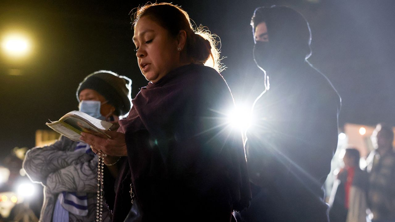 A person prays the rosary at a makeshift memorial outside the scene of a deadly mass shooting at a ballroom dance studio on January 23, 2023 in Monterey Park, California. 