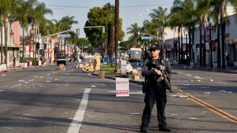 A Monterey Park police officer stands guard near where vendor tents once stood for the Lunar New Year festival near the Star Dance Studio in Monterey Park, California on January 22, 2023. 