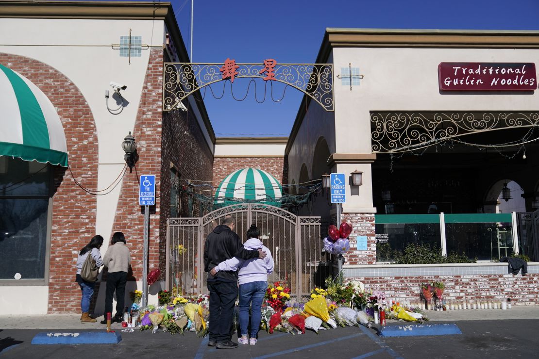 People stand near a memorial outside the Star Ballroom Dance Studio on January 24, 2023, in Monterey Park.