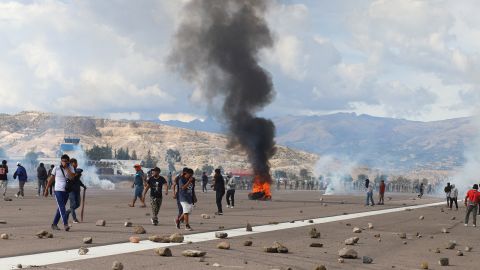 Göstericiler, 15 Aralık 2022'de Ayacucho, Peru'daki şiddetli protestoların ortasında bir havaalanı asfaltında duruyor. 
