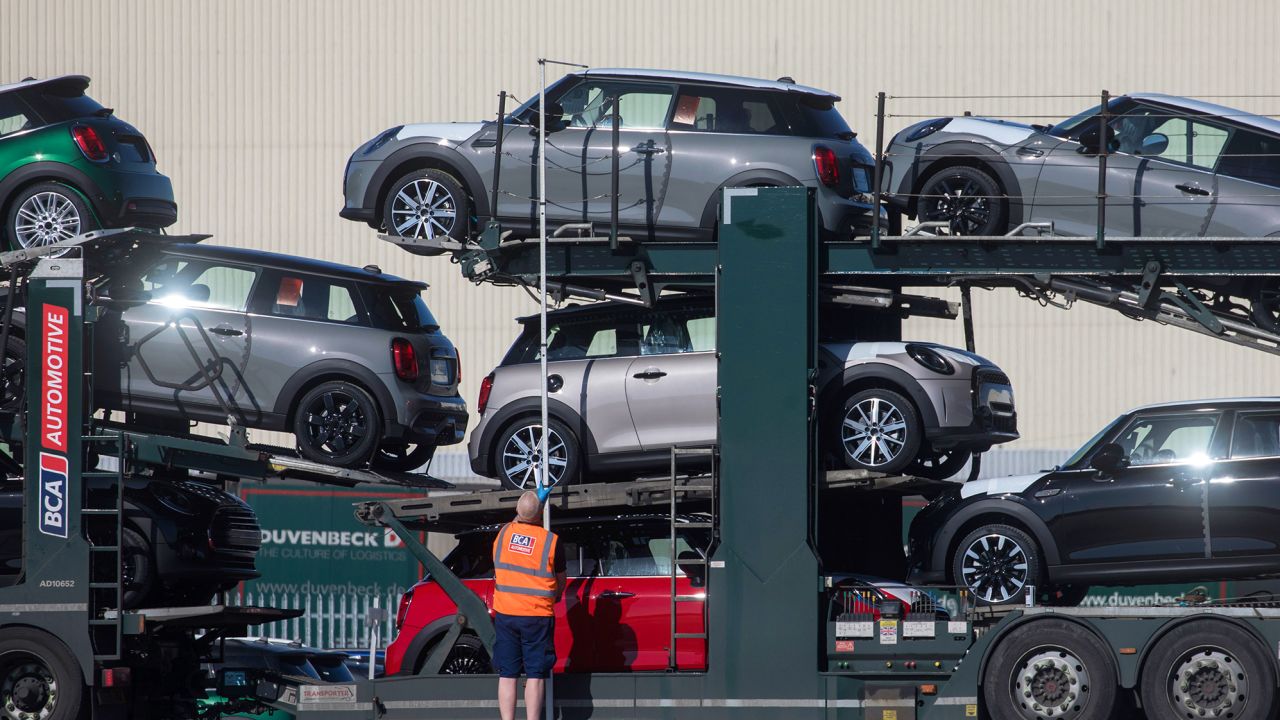 An employee checks the height of a transportation vehicle holding finished Mini automobiles at BMW's final assembly plant in Cowley near Oxford, UK, on March 9, 2021. BMW will relocate all production of the electric Mini to China.
