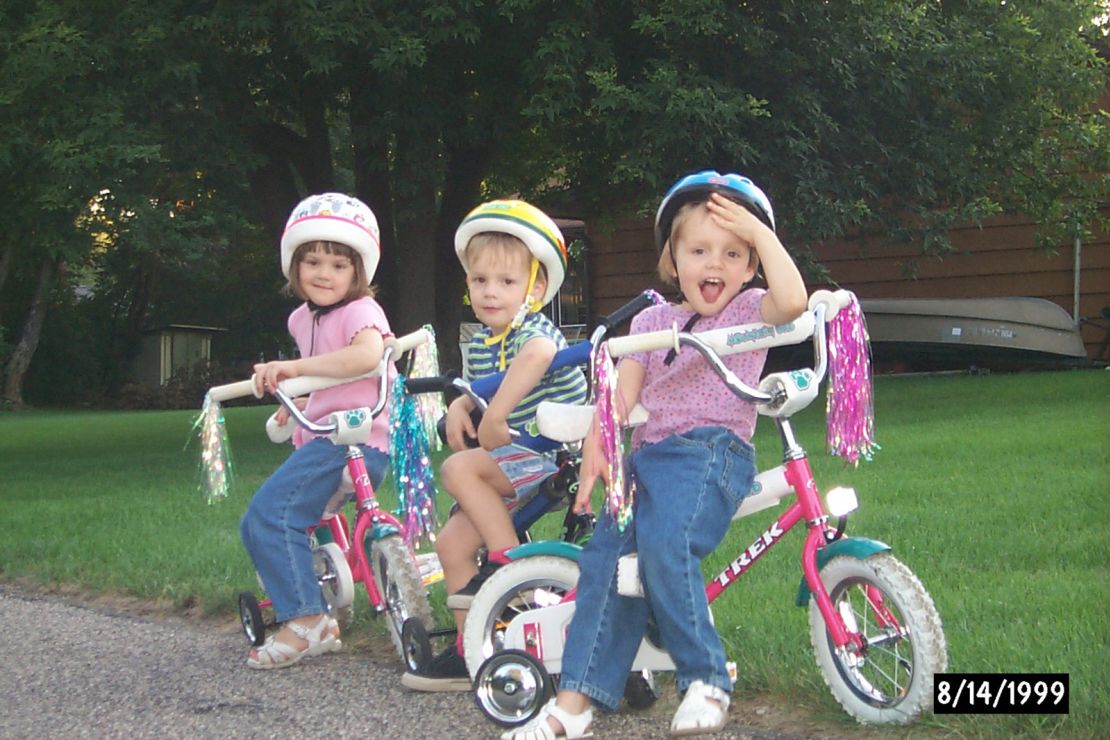 Kelly, along with her siblings Colin and Christine, pictured as a child on a bike ride in Minneapolis. Cycling was a passion from an early age, according to her father. 