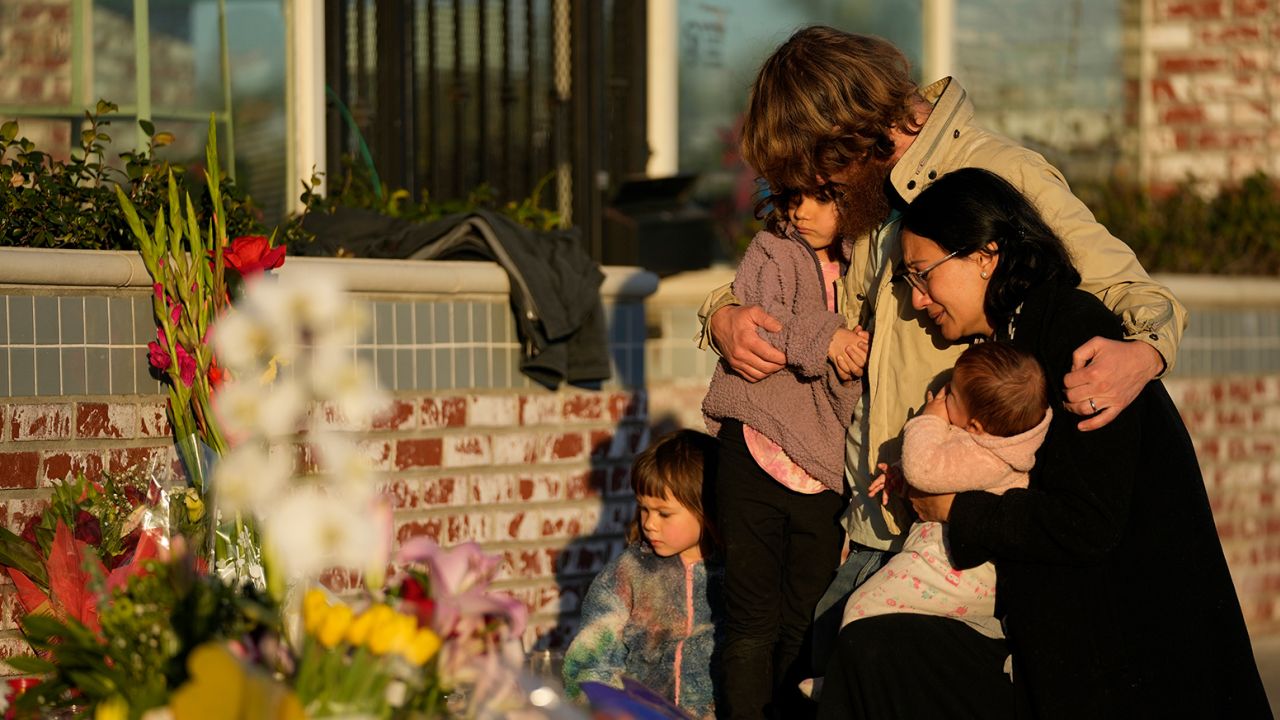 A family gathers Tuesday at a memorial at the Star Ballroom Dance Studio, in Monterey Park, California.