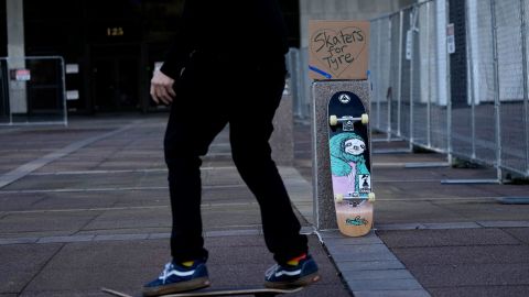 Skateboarders skate in front of city hall in remembrance of Nichols.