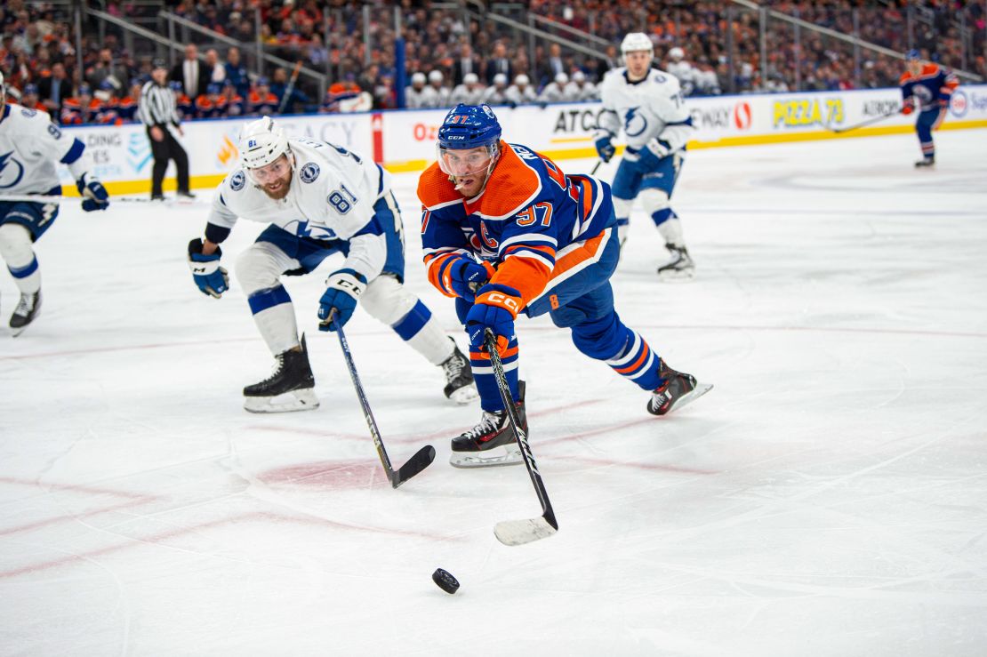 Connor McDavid of the Edmonton Oilers and Erik Cernak of the Tampa Bay Lightning battle for the puck.