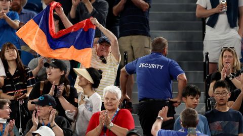 A fan displays the Armenian flag during Khachanov's match against Korda at the Australian Open.