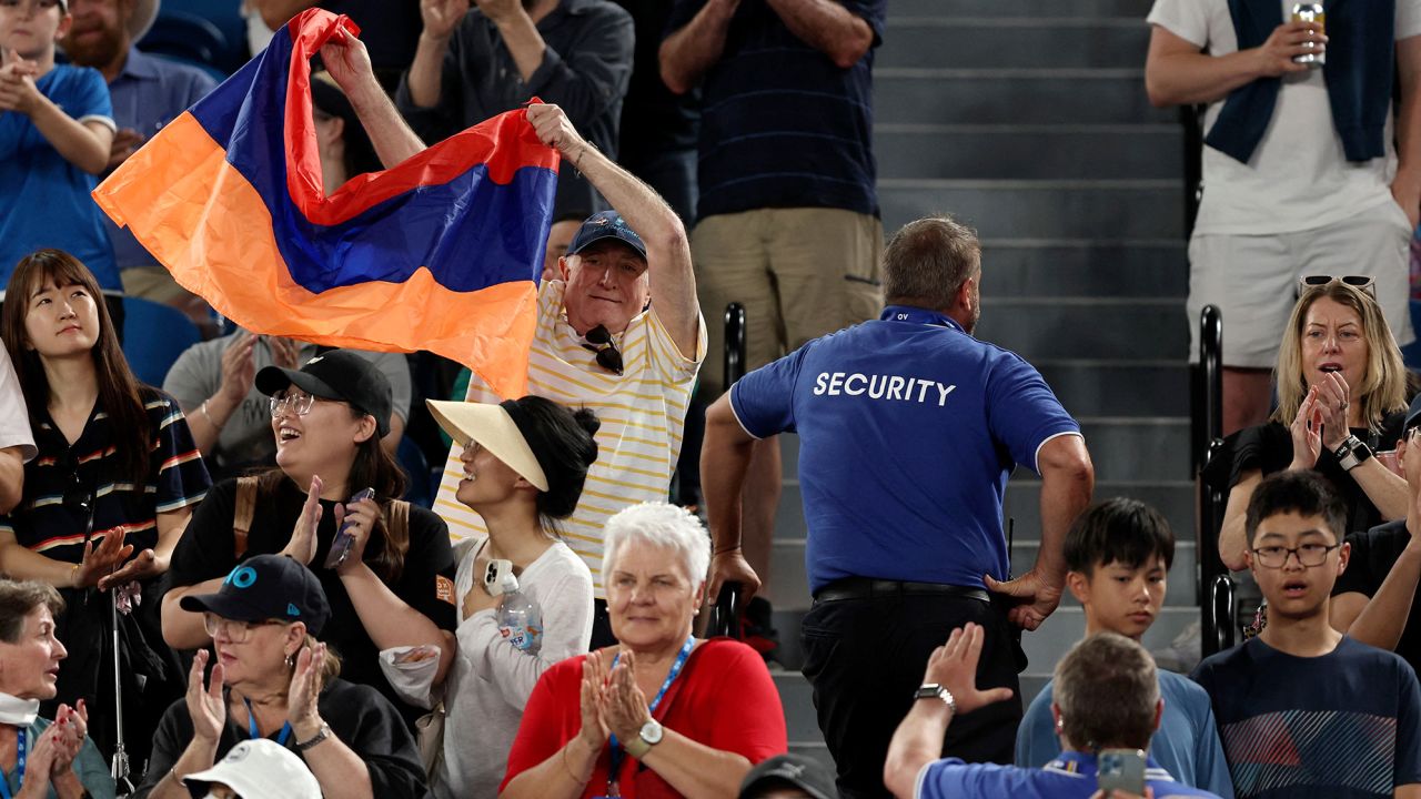A fan displays the Armenian flag during Khachanov's match against Korda at the Australian Open. 