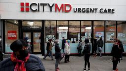 People wearing protective face masks wait in line outside a CityMD Urgent Care in the Bronx borough of New York during the COVID-19 outbreak in November 2020. 