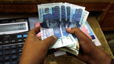 A trader counts Pakistani rupee notes at a currency exchange booth in Peshawar, Pakistan December 3, 2018.