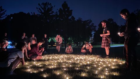 People gather in Musgrave Park, Brisbane, to light candles at the dawn of January 26, 2023.