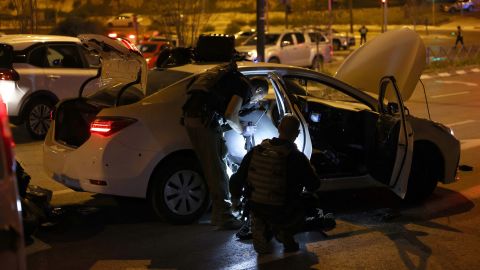 Les forces de sécurité israéliennes fouillent une voiture sur le site d'une attaque présumée dans un quartier de colons de Jérusalem-Est annexée par Israël, le 27 janvier 2023. 