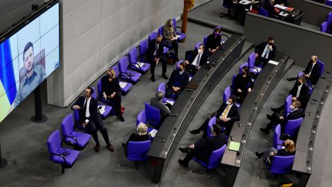 Members of the German government, among them German Chancellor Olaf Scholz (back right), listen as Ukrainian President Volodymyr Zelensky addresses via videolink at the German lower house of parliament in Berlin, March 17, 2022.