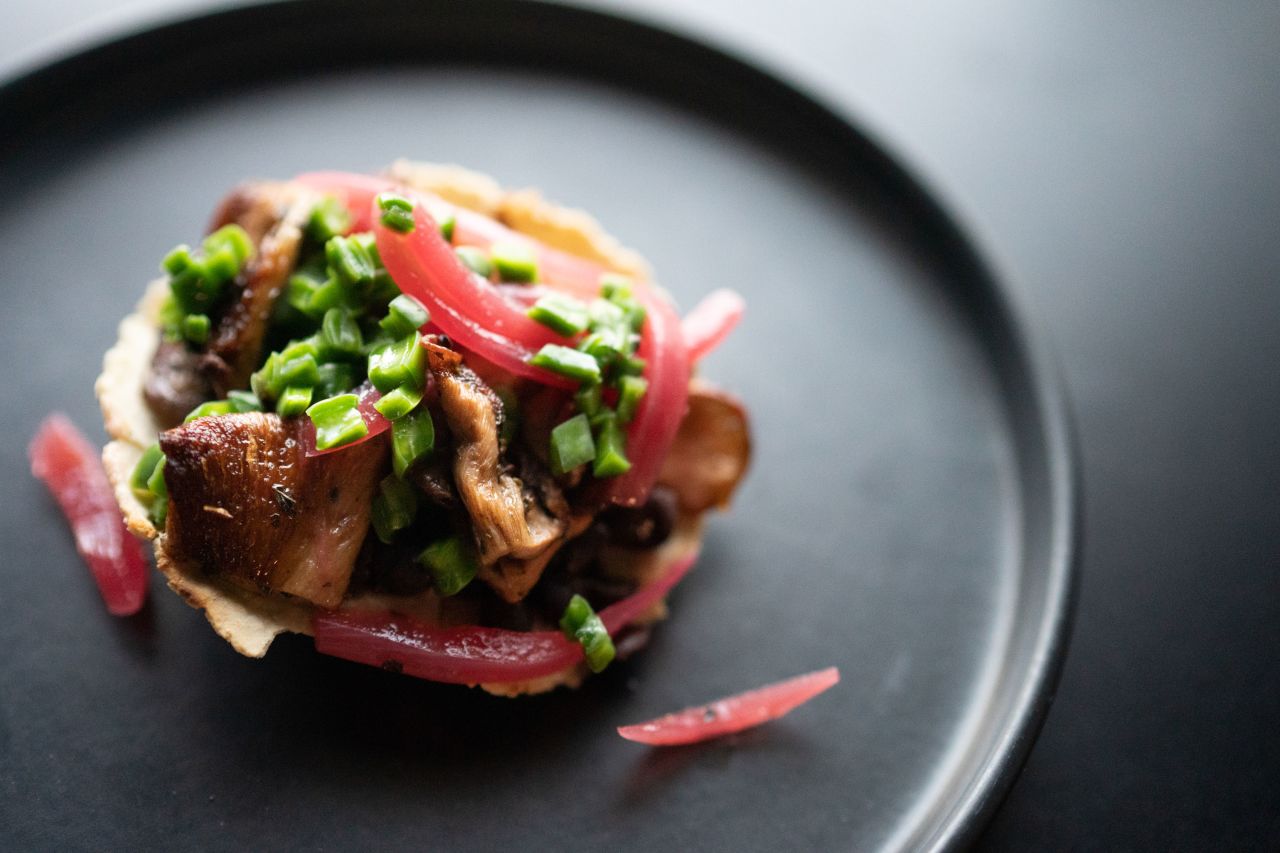 These tostadas are made with nopalitos, the tender pads of cactus that have a tart, citrus flavor, and paired with black beans and pickled red onion.