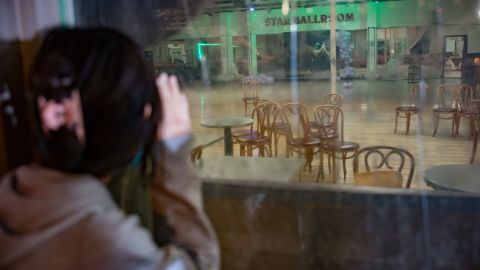 A girl peers through the window of the Star Ballroom Dance Studio, which is indefinitely closed following the shooting. 