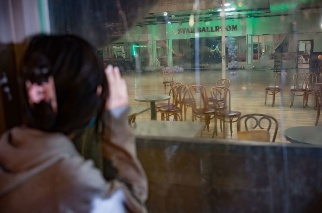 A girl peers through the window of the Star Ballroom Dance Studio, which is indefinitely closed following the shooting. 