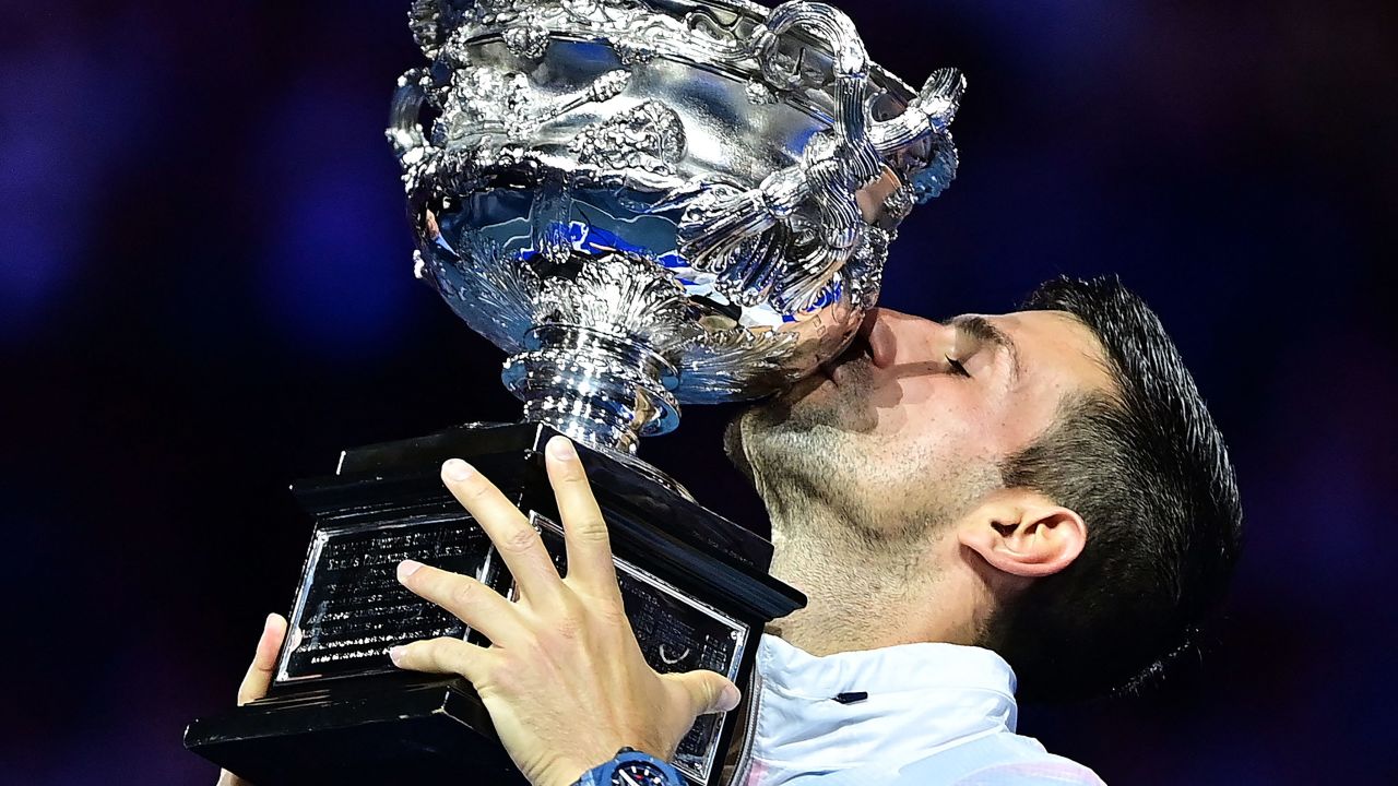 Serbia's Novak Djokovic celebrates with the Norman Brookes Challenge Cup trophy following his victory against Greece's Stefanos Tsitsipas in the men's singles final match on day fourteen of the Australian Open tennis tournament in Melbourne on January 29, 2023.