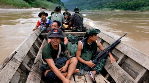 Members of a rebel group in Myanmar's eastern Karenni state on a boat, going from the Thai border into Myanmar.