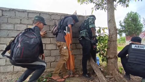 Combat medics from the Moebye PDF Rescue Team hide behind a wall as they prepare to rescue rebel fighters in Moe Bye, Myanmar, on September 9, 2022.