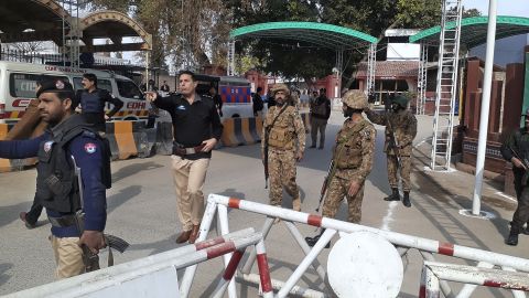 Soldiers and police officers clear the way for ambulances rushing toward the explosion site in Peshawar, Pakistan, January 30, 2023. 