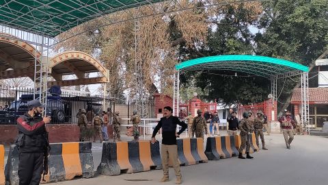 Security guards stand guard outside police headquarters after an explosion in Peshawar.