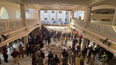 Security officials inspect the site of the mosque suicide attack in Peshawar.