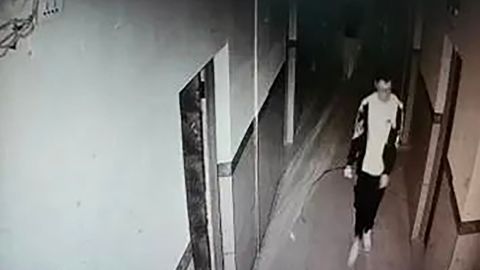This screenshot from surveillance camera footage shows Hu Xinyu walking down a hallway in his bedroom.