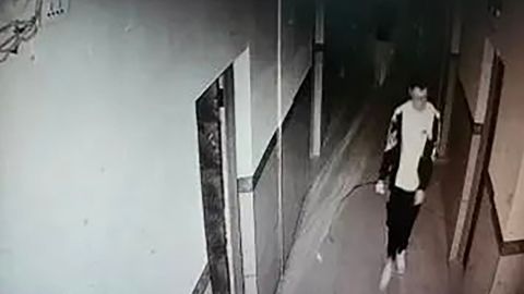 This screengrab from surveillance camera footage shows Hu Xinyu walking down a hallway in his dormitory.