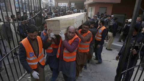 Volunteers carry the coffin of a man killed in a suicide bombing in Peshawar on Monday.